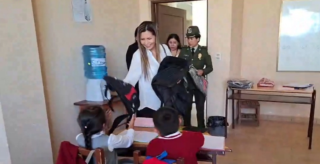 Fiscal departamental, Sandra Gutierrez, entregando mochilas a niños de la U.E. Moto Méndez, Tarija. Captura: Play Noticias