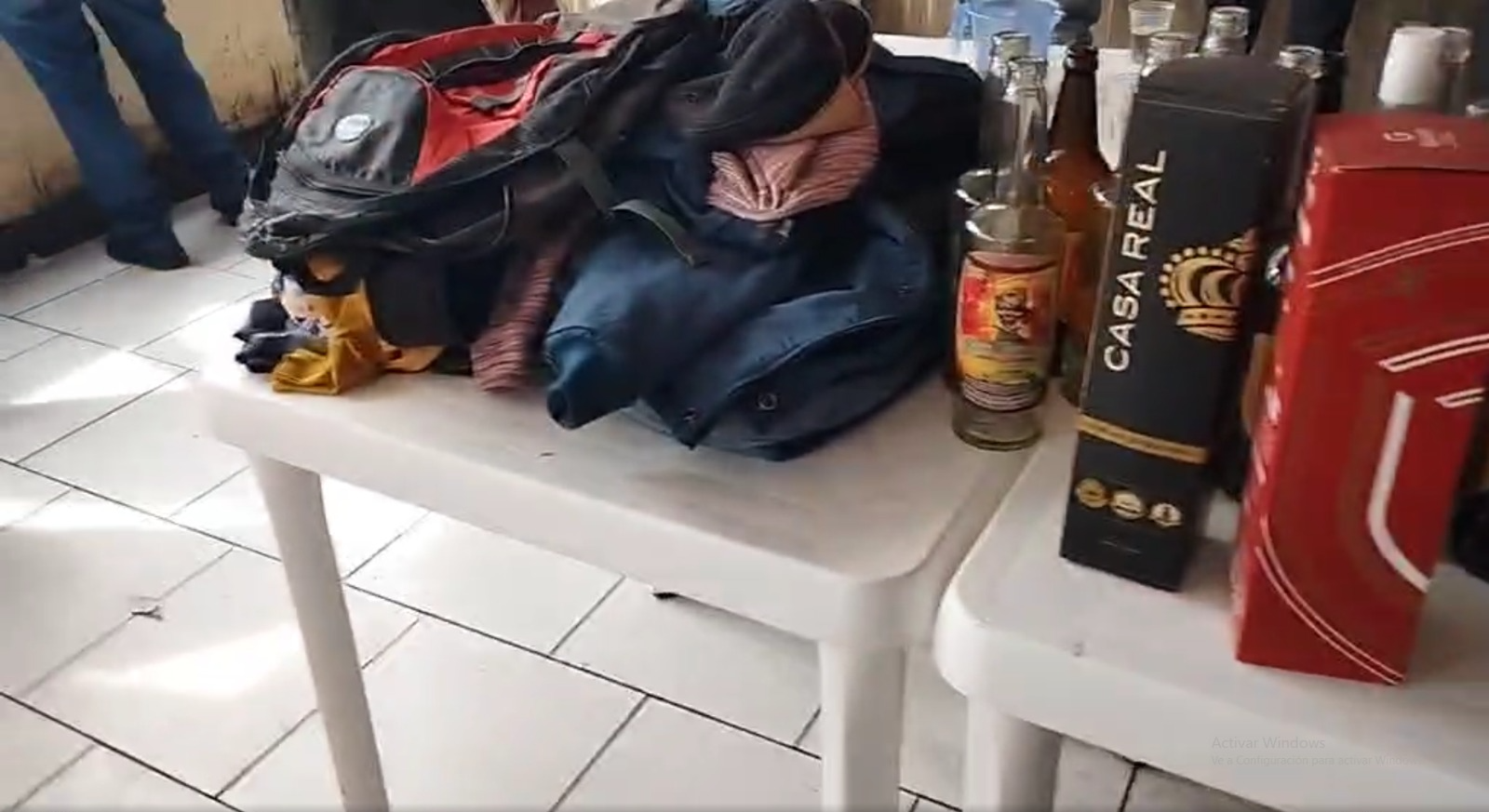 Mochila "sin dueño" y bebidas adulteradas al interior del bar clandestino intervenido por la Policía en El Alto. Captura: El Alto es noticia