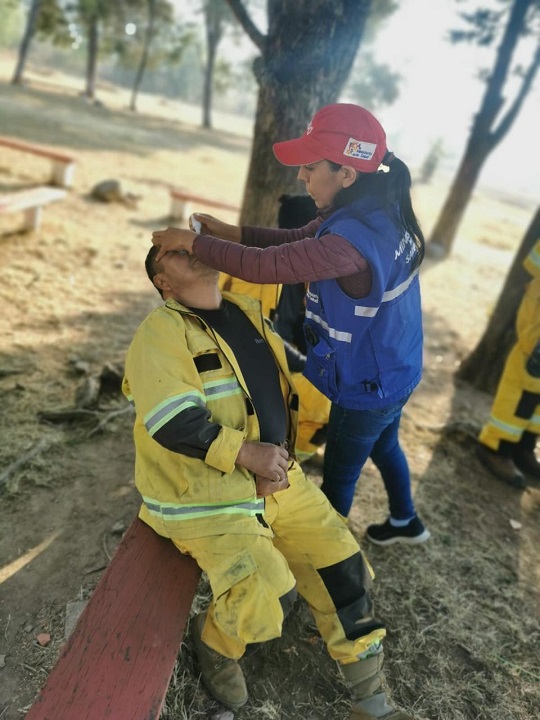 Brigada médica atiende a una persona afectada por los incendios forestales. Foto Min. Salud