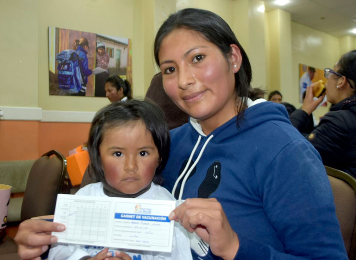 Una madre con el esquema de vacunación de su pequeña. Foto Min. Salud