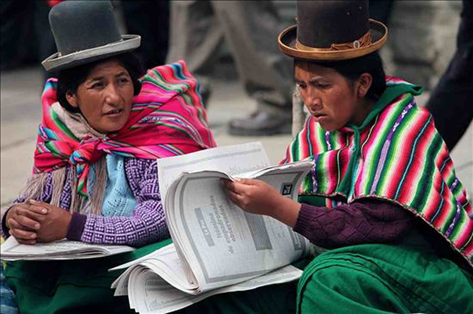 Mujeres aymaras con una publicación en castellano. Foto RRSS